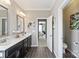 This luxurious bathroom boasts dual sinks, tile floors, neutral walls, and an open doorway to the bedroom at 2511 Carnation Dr, Harrisburg, NC 28075