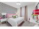 Cozy bedroom showcasing stylish wallpaper, bright pink accents, and ample natural light at 2511 Carnation Dr, Harrisburg, NC 28075