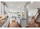 Open concept kitchen with white cabinets, stainless appliances, island and adjacent dining area at 2511 Carnation Dr, Harrisburg, NC 28075