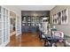 Spacious home office with custom built-ins, desk area, and hardwood flooring at 2511 Carnation Dr, Harrisburg, NC 28075