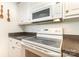 Close up of oven and microwave in a well-lit white kitchen with granite countertops at 302 6Th Sw St, Conover, NC 28613