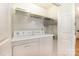 Bright laundry room with a washer, dryer, wire shelving and white cabinets at 302 6Th Sw St, Conover, NC 28613