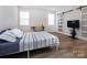 Bright bedroom featuring a bed, a TV, a desk, and a sliding barn door for a modern, functional space at 3252 Cheyney Park Dr, Charlotte, NC 28269