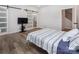 Bedroom features wood flooring and a barn door leading to the ensuite bathroom at 3252 Cheyney Park Dr, Charlotte, NC 28269