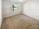 Cozy bedroom featuring neutral carpet and a window offering a pleasant view at 3510 Heathcott Cir, Charlotte, NC 28262