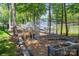 A charming backyard featuring a greenhouse, garden plot, and tranquil views of the lake with docks at 3992 Blue Dory Ln, Denver, NC 28037
