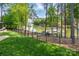 Fenced backyard with well-manicured lawn and a scenic view of the lake and boat docks through the trees at 3992 Blue Dory Ln, Denver, NC 28037