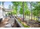 Inviting backyard featuring a spacious deck, lake access, and a charming greenhouse nestled among the trees at 3992 Blue Dory Ln, Denver, NC 28037