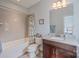 Neutral bathroom featuring a tiled tub and shower with granite counters, and a decorative patterned shower curtain at 3992 Blue Dory Ln, Denver, NC 28037