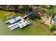 Aerial view of a private dock with multiple boat slips, lounge chairs, and scenic lake surroundings at 3992 Blue Dory Ln, Denver, NC 28037