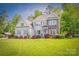 Charming two-story home with stone accents, gray siding, shutters, manicured lawn, and an American flag on display at 3992 Blue Dory Ln, Denver, NC 28037