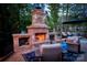 Outdoor fireplace area with stone accents, comfortable seating, and a view of the surrounding landscape at 3992 Blue Dory Ln, Denver, NC 28037
