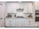 Close-up of a modern kitchen with white cabinets, stainless steel appliances, and granite countertops at 3992 Blue Dory Ln, Denver, NC 28037