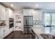 Bright kitchen with white cabinets, stainless steel appliances, and dark wood flooring at 3992 Blue Dory Ln, Denver, NC 28037