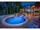 Stunning backyard pool area with a spa, stone accents, and elegant lighting, ideal for outdoor entertainment at 3992 Blue Dory Ln, Denver, NC 28037