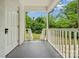 Covered back porch with white railings, offering a view of the green backyard and a private entrance at 4021 Paisley Pl, Charlotte, NC 28208