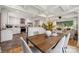 Inviting dining area with a wooden table set and an open view into a modern kitchen and sunlit living room at 4021 Paisley Pl, Charlotte, NC 28208