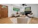 Bright living room with hardwood floors, large windows, stylish furniture, and a cozy fireplace at 4021 Paisley Pl, Charlotte, NC 28208