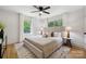 Bright main bedroom with plush bedding, modern side tables, and hardwood floors, offering a peaceful retreat at 4021 Paisley Pl, Charlotte, NC 28208