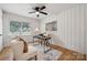 This home office features white vertical paneling, a modern desk, cozy seating, and a large window for natural light at 4021 Paisley Pl, Charlotte, NC 28208
