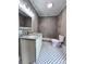 A bathroom with decorative flooring, gray tiled shower, and a granite countertop at 419 S Spencer Ave, Spencer, NC 28159
