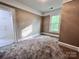 This bedroom has tan walls, carpeting, a window, and white trim at 419 S Spencer Ave, Spencer, NC 28159