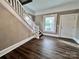 A home entryway features wood-look floors, a staircase with white railing, and a door leading to the outside at 419 S Spencer Ave, Spencer, NC 28159