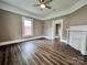 Inviting living room with dark wood floors, a ceiling fan, and an ornate fireplace. Open doorways lead to adjoining rooms at 419 S Spencer Ave, Spencer, NC 28159