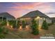 Backyard featuring manicured shrubs and a stone patio with comfortable seating and a grill at 45523 Misty Bluff Dr, Charlotte, NC 28278