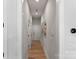 Hallway with white trim, hardwood floors, neutral paint, and visible thermostat at 45523 Misty Bluff Dr, Charlotte, NC 28278