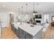 Bright, open kitchen features a large island, farmhouse sink, modern lighting and stainless steel appliances at 45523 Misty Bluff Dr, Charlotte, NC 28278