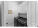 Neat laundry area featuring washer and dryer beneath storage cabinets at 45523 Misty Bluff Dr, Charlotte, NC 28278
