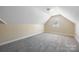 A finished attic features neutral paint, carpet, window and a sloped ceiling at 4790 Cascade Ave, Rock Hill, SC 29732
