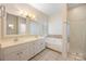 Bright bathroom featuring double sinks, a soaking tub, and a glass door shower at 4790 Cascade Ave, Rock Hill, SC 29732