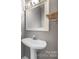 Chic powder room featuring a pedestal sink, modern mirror, and stylish fixtures, perfect for guests at 4790 Cascade Ave, Rock Hill, SC 29732