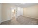 Spacious carpeted bedroom featuring neutral walls, and open doorway to stairs at 4790 Cascade Ave, Rock Hill, SC 29732