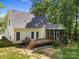 Rear exterior view features a deck and screened-in porch, enhancing outdoor living amidst lush greenery at 4790 Cascade Ave, Rock Hill, SC 29732