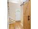 Welcoming hallway with hardwood floors, staircase, and stylish barn door, blending modern and traditional elements at 4790 Cascade Ave, Rock Hill, SC 29732
