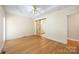 Bright main bedroom featuring wood floors, a barn door to the bathroom, and a tray ceiling with fan at 4790 Cascade Ave, Rock Hill, SC 29732