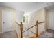 View of the staircase with wood and white railing leading to a bright foyer with a window at 4790 Cascade Ave, Rock Hill, SC 29732