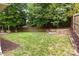 The backyard showcases a lush lawn, a wooden fence, and mulched garden beds ready for planting at 508 Long Creek Pkwy, Charlotte, NC 28214