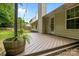 A backyard with green grass features a wood deck, mature trees and string lights at 508 Long Creek Pkwy, Charlotte, NC 28214