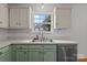 Traditional kitchen with green lower cabinets and a stainless steel dishwasher and sink at 508 Long Creek Pkwy, Charlotte, NC 28214