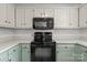 Traditional kitchen with green lower cabinets and black appliances at 508 Long Creek Pkwy, Charlotte, NC 28214