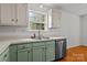 Traditional kitchen with green lower cabinets and a stainless steel dishwasher and sink at 508 Long Creek Pkwy, Charlotte, NC 28214