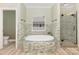 Luxurious bathroom with a soaking tub and separate glass-enclosed shower at 6729 Garden Hill Dr, Huntersville, NC 28078