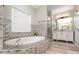 Lovely bathroom features a soaking tub with mosaic surround, a glass-enclosed shower, and a double vanity at 6729 Garden Hill Dr, Huntersville, NC 28078
