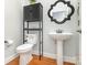 Small powder room with a pedestal sink, modern toilet, and decorative mirror at 6729 Garden Hill Dr, Huntersville, NC 28078