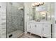 Modern bathroom with a glass shower, marble tile, and vanity with double sinks at 6729 Garden Hill Dr, Huntersville, NC 28078