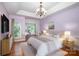Comfortable bedroom features a tray ceiling, chandelier, and access to a cozy sitting area with lots of light at 6729 Garden Hill Dr, Huntersville, NC 28078